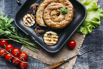 Grill pan with delicious spiral grilled sausage and vegetable