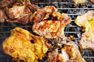 Grilling chicken and pork meat on the grill.