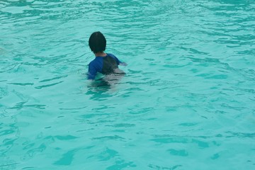 A teenager is playing in the pool.