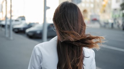Hair treatment. Confident teen girl walking. City center.