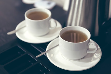 pair of white ceramic cups with tea