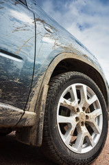 Fototapeta na wymiar Dirty SUV car stands on rural road