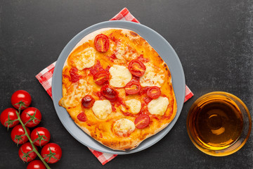 Pizza Margherita with ingredients on black background.