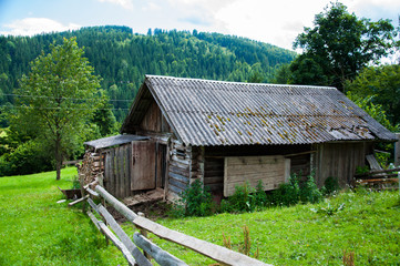 Old wooden house in the mountains. On high. Against the backdrop of mountains and forests