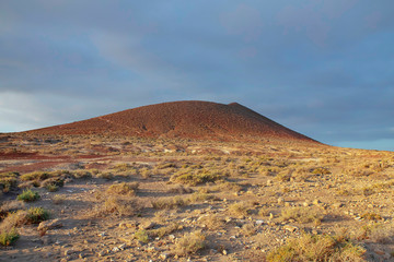 Overcast sunrise over Montana Roja Special Natural Reserve, an unusual volcanic cone, one of the best example of inorganic sand habitats on the island, in El Medano, Tenerife, Canary Islands, Spain