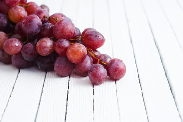 bunch of red grape on white wooden