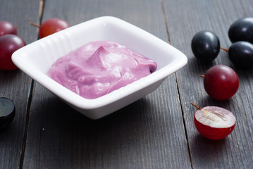 cosmetic cream from red grapes on black wooden