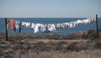 ropa tendida en mitad de la nada con el mar de fondo