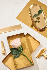 Gold items. Flat lay. Accessories on the table, woman desk top. View top table, background mock up. Envelope top