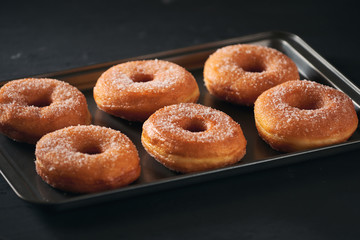 Donuts with sugar on a tray in a bar