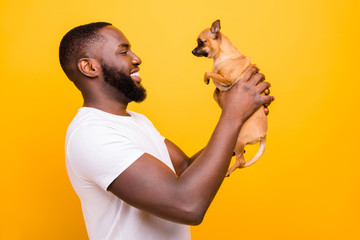Profile photo of dark skin guy talking to lovely little pet wear casual outfit isolated yellow background