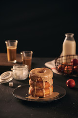 Close-up of donuts in stack with milk bottle and glass
