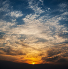 Dramatic sunset sky with orange colored clouds.