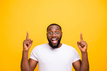 Close up photo of casual crazy rejoicing black man calling you to look up and buy what is specified there while isolated with vivid background - obrazy, fototapety, plakaty