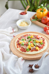 Raw pizza dough with tomato sauce, ingredients