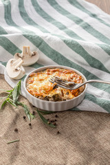 julienne with mushrooms and melted cheese on grey tablecloth