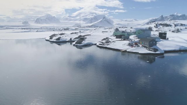 Antarctic Vernadsky Station Epic Aerial View. Polar Ocean Coast Open Water Peaceful Surface. South Pole Settlement Base on Mountain Peninsula Landscape Background Drone Flight Footage Shot in 4K (UHD)