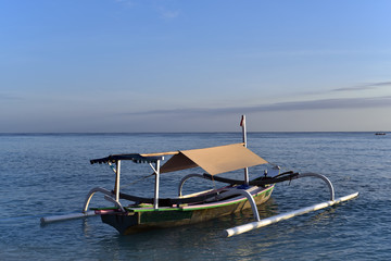 Fototapeta na wymiar Traditional fishing boat docked on the shore in sunrise, Gili Meno Island, Indonesia