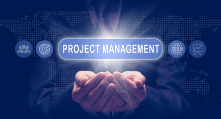 Businessmans cupped hands holding a Project Management business concept on a computerised display.