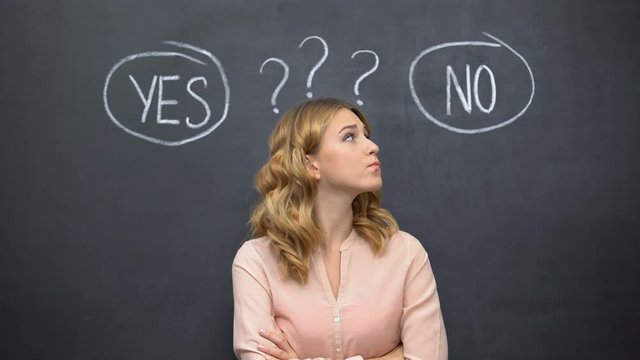 Puzzled woman choosing between yes no, stereotype of uncertain female thinking