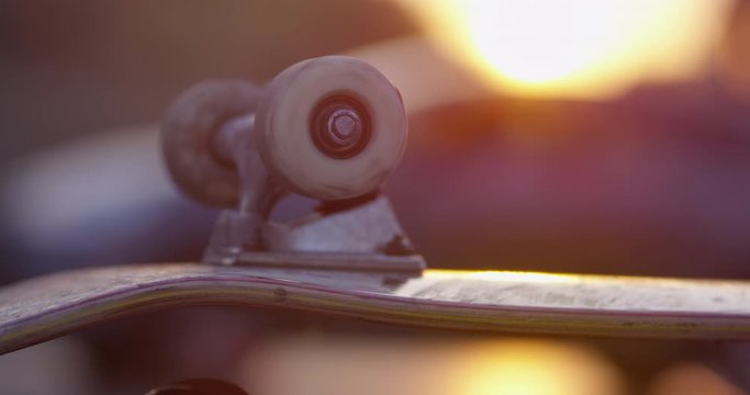 Close shot of a skateboard's wheels with a beautiful sunset, golden hour skateboarding in the city of Montpellier, France