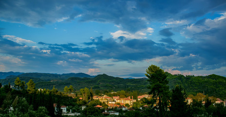 top panoramic beautiful colorful view of Asian settlement in rainy forest scenic landscape natural environment hills in slightly cloudy sunset evening time 