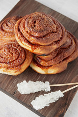 Homemade sweet cinnamon buns with sugar on wooden cut board