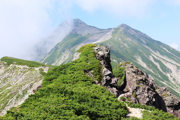 北アルプス笠ヶ岳への道　縦走路から抜戸岩越しに笠ヶ岳山頂を望む