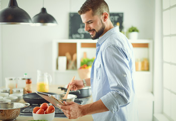 Smiling and confident chef standing in large kitchen