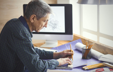 Engineer carpenter working on laptop and sketching project