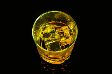Glass of scotch whiskey and ice on a black background