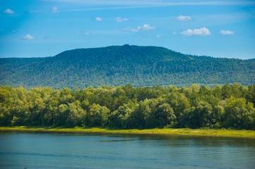 far Bank of the river with green trees and blue mountain