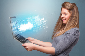 Woman holding laptop projecting notifications, symbols and information based on cloud technology system