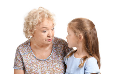 Cute little girl with grandmother on white background