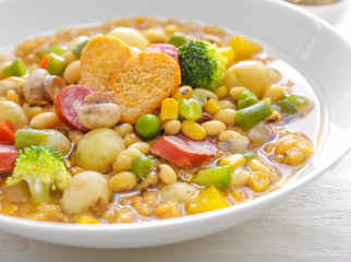 Tasty soup with legumes in bowl on table