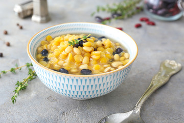Tasty soup with legumes in bowl on grey background