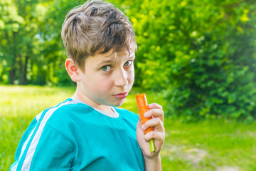 teen boy with a carrot in a forest