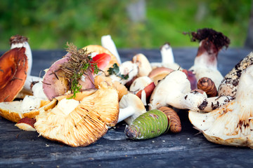 Forest mushrooms on the old wooden background. Fresh raw mushrooms on the table.