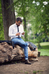 businessman in park  working and drinking coffee