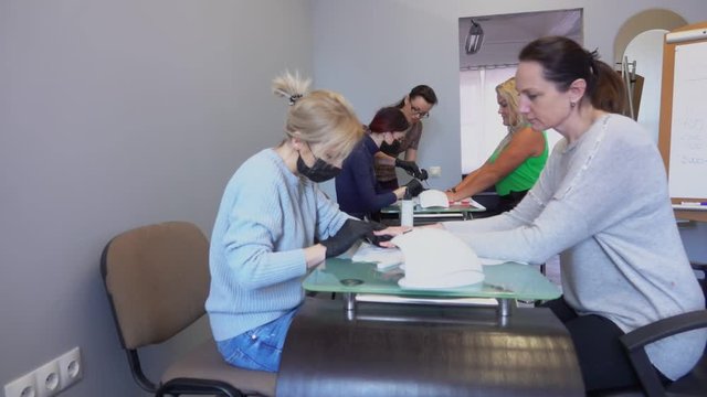 Manicure masters take part in retraining courses under the guidance of a teacher