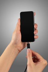 Close-up view of hand charging smartphone