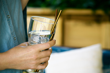 Woman holds a glass of water with reusable metal straws.  Sustainable lifestyle and zero waste concept, plastic free