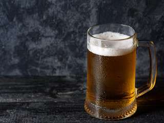 Beer mug with light beer on dark background