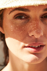 Freckled and sunlit beautiful woman in close up