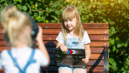 Little girls record a video blog on the camera Two children of 5 years old on the street are...