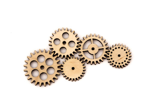 connected wooden gears of different size isolated on white background.
