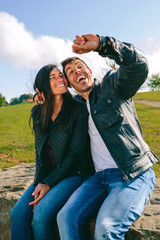 Happy young couple taking a selfie with a smartwatch outdoors