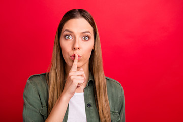 Photo of charming beautiful lady pointing out to you that there is no need in talking while isolated with red background