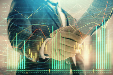 Double exposure of financial graph on cityscape background with two businessman handshake. Concept of stock market deal
