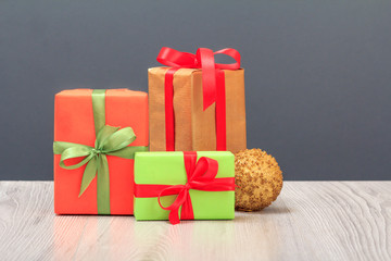 Gift boxes, toy ball and fir tree branch on gray background